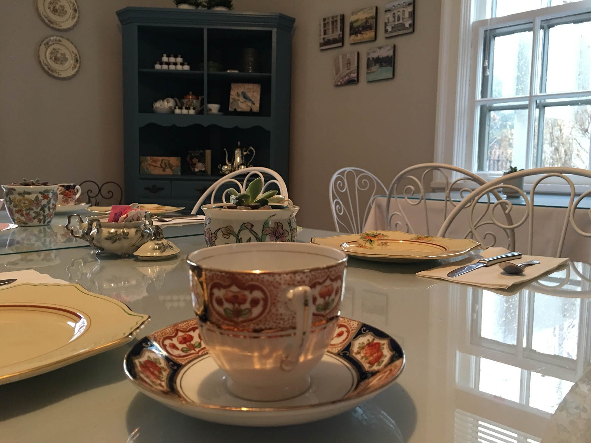 A table set up with antique china for a lunch with teacups and plates