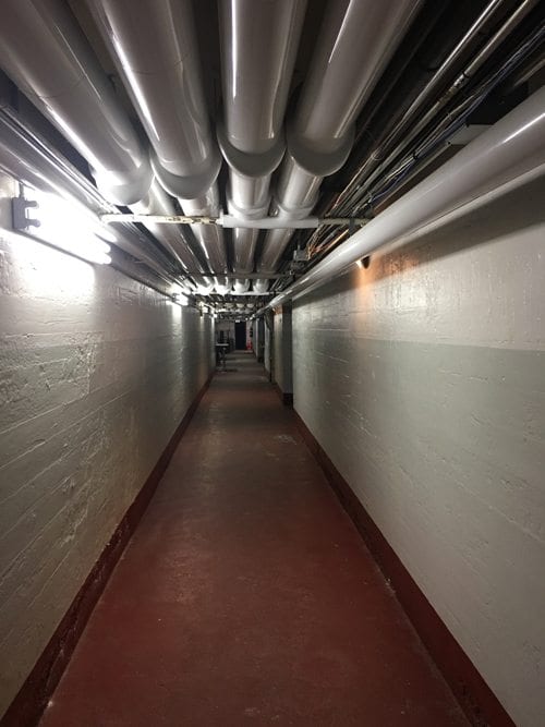 Long hallway with pipes on the ceiling